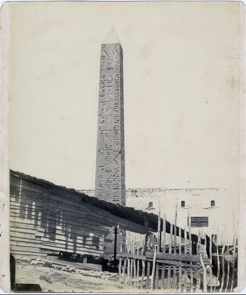 Image of one of the two obelisks originally erected in Heliopolis by Thutmose III but later transported to Alexandria by the Romans (at the behest of Augustus) and placed in a temple dedicated to Queen Cleopatra (Cleopatra VII). This led to the common name Cleopatra's Needle (Needles). The first obelisk was donated to Great Britain and arrived in London in 1877, the second to the United States and erected in Central Park, New York on 22 February 1881. The one now standing in Central Park is recognisable in the image. Visible on the wall of the building in the background is an Italian plate for transport via railway.