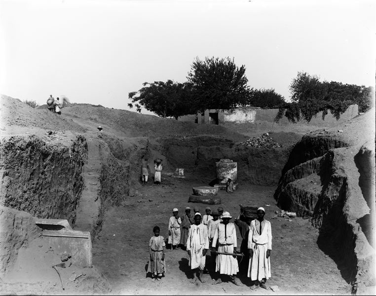 Trench in Kom, with “late period” columns. In the background, Arabic houses also near kom. Schiaparelli excavations.