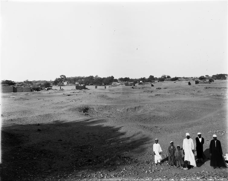 View of Kom, with Arabic houses. In the foreground, some of the workers in the team are posing for the camera. Schiaparelli excavations.