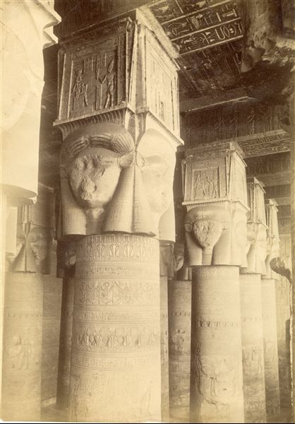 La fotografia ritrae il colonnato della sala ipostila, di età romana, del tempio di Hathor a Dendera. Da notare le iscrizioni sul soffitto e i capitelli hathorici (capitelli con la testa della dea Hathor scolpita in rilievo su ogni lato) ulteriormente decorati con scene sacre. Lo scatto è attribuibile ad Antonio Beato.