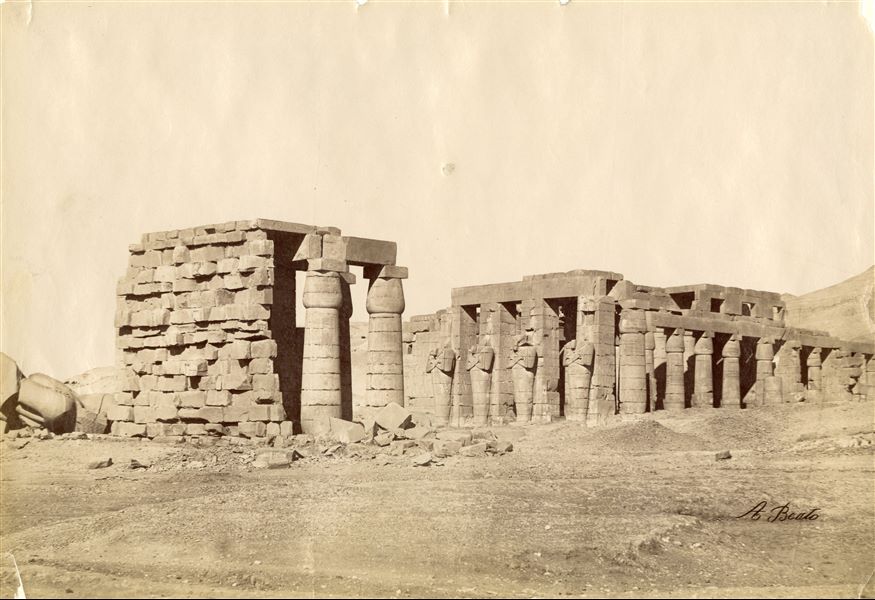 View of the remains of the Ramesseum, the Funerary Temple built by Pharaoh Ramesses II on the west bank of the Nile near ancient Thebes. Four Osiride pillars representing the pharaoh himself can be seen. The author's signature is visible at the bottom right.