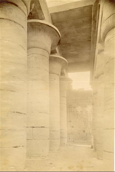 Fotografia della Sala Ipostila del Ramesseo, il tempio funerario di Ramesse II a Tebe Ovest. Sul muro di fondo, è visibile la scena con Ptah, Amon e Ramesse II (a destra, nascosta dalla colonna, è presente anche la figura della dea Tefnut). La fotografia è attribuibile ad Antonio Beato. 