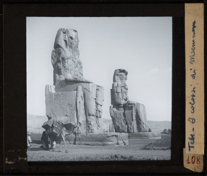 Side view of the so-called Colossi of Memnon: a pair of statues representing Pharaoh Amenhotep III seated on his throne.