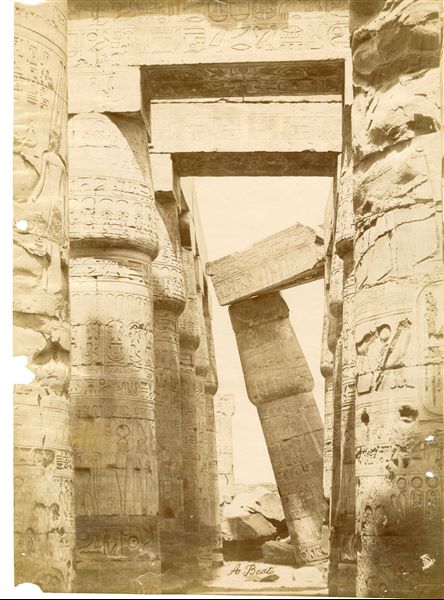 The image shows part of the lateral colonnade of the Great Hypostyle Hall of the Karnak Temple Complex with papyrus columns which have not yet been completely cleared of sand. The author's signature can be found at the bottom.   