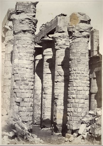 Particolare della navata centrale della Grande Sala Ipostila del complesso templare di Amon a Karnak. Il livello del suolo copre ancora parzialmente le basi delle colonne. La firma dell’autore si trova in basso a sinistra.