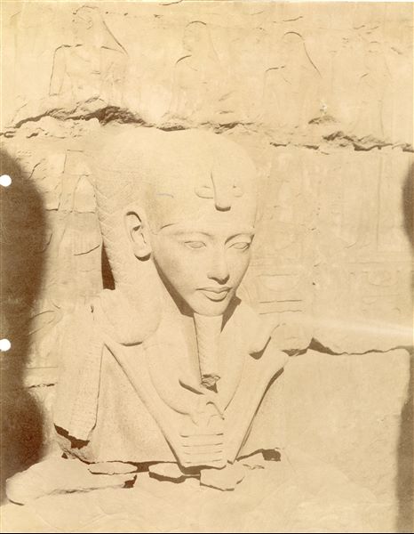The photograph presents a close-up of the fragmentary bust of the statue of the god Khonsu, depicted in the likeness of Tutankhamun, in the Temple of Amun at Karnak. 