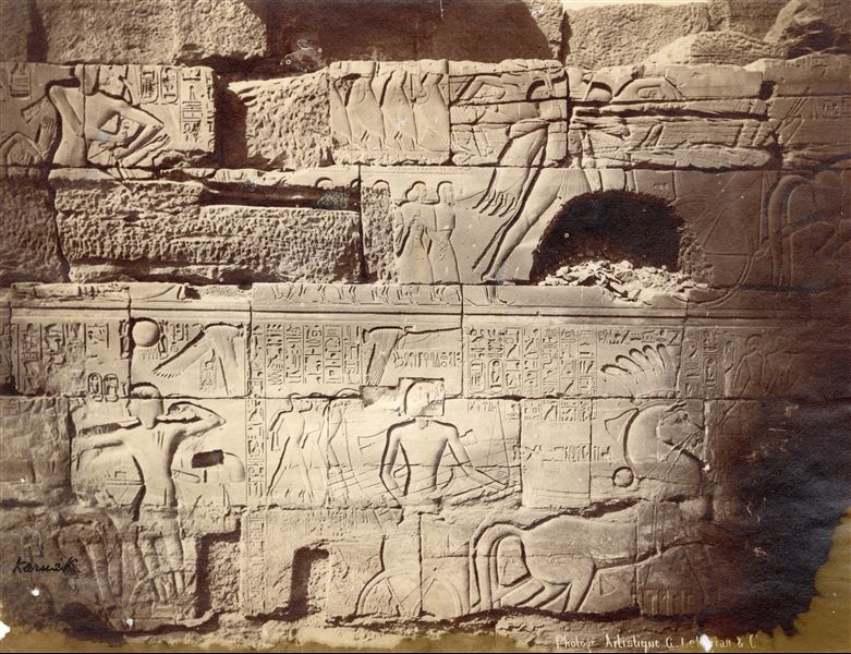 The photograph shows a detail of the external wall’s decoration, north side, of the Great Hypostyle Hall built by Pharaoh Seti I in the Temple of Amun at Karnak, showing battle scenes against the Syrio-Palestinians. The author's signature is at the bottom right.   