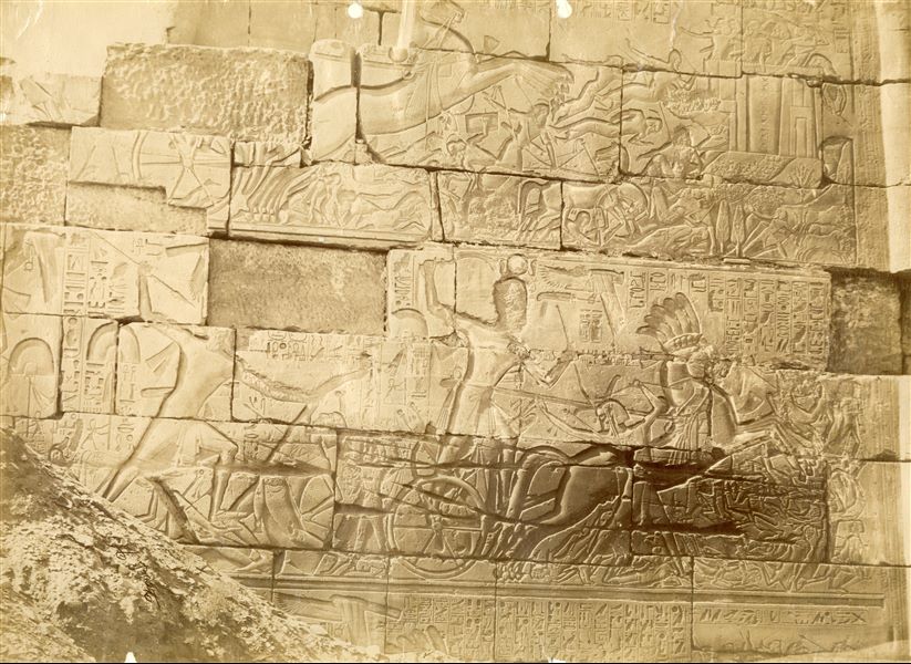 The image depicts some battle scenes of Pharaoh Seti I on the outer wall, north side, of the Great Hypostyle Hall in the Karnak Temple Complex. The author's signature is visible at the bottom left. 