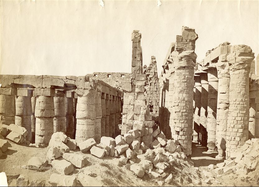 La fotografia mostra la sezione longitudinale della Grande Sala Ipostila del complesso templare di Amon a Karnak, assieme alle rovine dei muri crollati. In basso a destra è presente la firma degli autori.