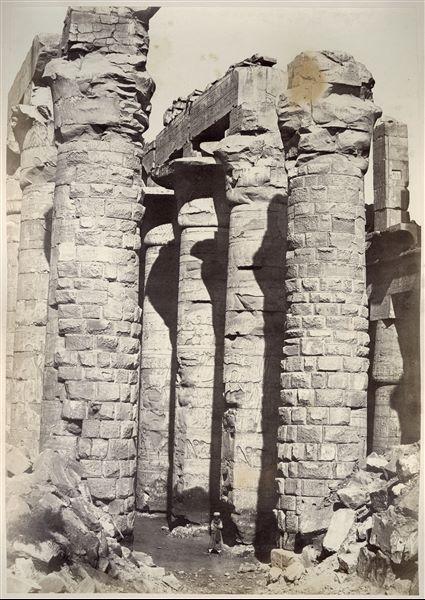 Detail of the central nave of the Great Hypostyle Hall from the Karnak Temple Complex. The ground level still partially covers the columns' bases. The author's signature can be found at the bottom right. 