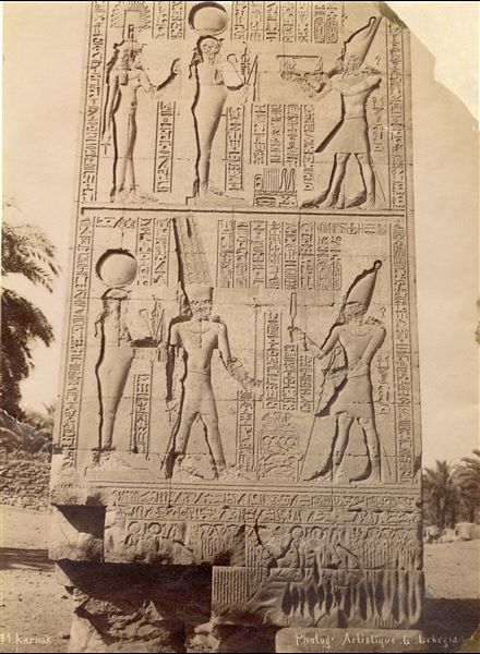The photograph depicts a detail of decorated relief on the western gate built by King Ptolemy IV on the walls of the Karnak Temple Complex. The author's signature is at the bottom right. 