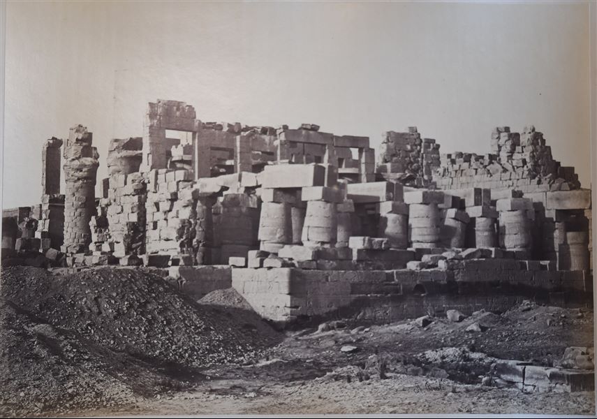 Veduta dei resti della Grande Sala Ipostila nel complesso templare di Amon a Karnak. Il livello del suolo copre ancora la parte inferiore del muro perimetrale della sala. In basso a destra, la firma dell’autore.