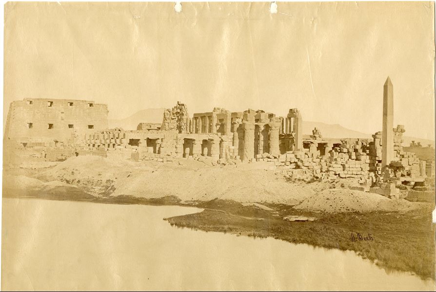 L’immagine mostra l'insieme degli elementi strutturali che compongono la Grande Sala Ipostila ramesside del complesso templare di Amon a Karnak, dietro la quale si riconosce il I pilone. Da questo inquadramento, preso dal Lago Sacro, in primo piano, svettano l'obelisco di Hatshepsut e quello di Thutmosi I. La firma dell'autore, scritta con calligrafia diversa da quella usuale, è apposta in basso a destra.  