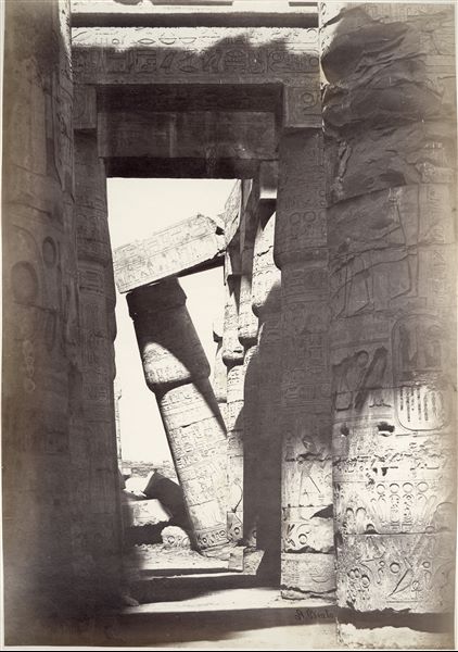 Detail of some columns in the Great Hypostyle Hall from the Karnak Temple Complex. The ground level still partially covers the columns' bases. The author's signature can be found at the bottom right. 