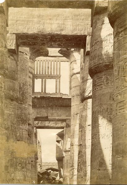 La fotografia ritrae uno scorcio della Grande Sala Ipostila del complesso templare di Amon a Karnak, in particolare la caratteristica finestra "a claustra". In basso si trova la firma dell’autore.