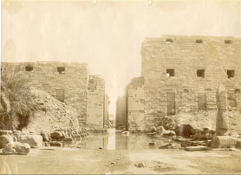 The photograph shows the main entrance to the Karnak Temple Complex (first pylon) from the Avenue of the Sphinxes with ram's head. This striking shot shows the ruins of the temple complex submerged in water during one of the Nile's floods. The photo can be attributed to Antonio Beato.   
