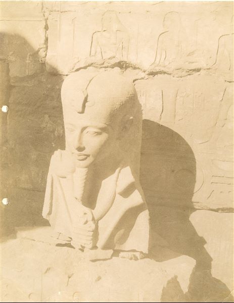 La fotografia ritrae il busto di una statua frammentaria del dio Khonsu con sembianze di Tutankhamon, trovata nel complesso templare di Amon a Karnak. La scultura, 
ricomposta successivamente grazie al rinvenimento di ulteriori frammenti negli scavi Legrain del 1904, si trova ora la Museo Egizio del Cairo (Cairo CG 39488).