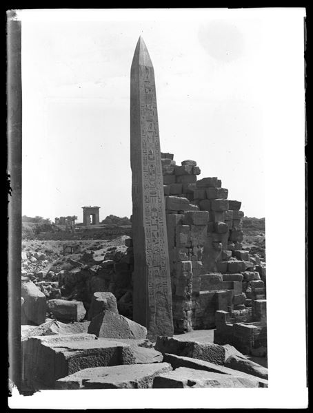 Obelisco di Tutmosi I presso il complesso templare di Karnak e sullo sfondo si riconosce la grande porta monumentale occidentale, il portale di Tolomeo IV.