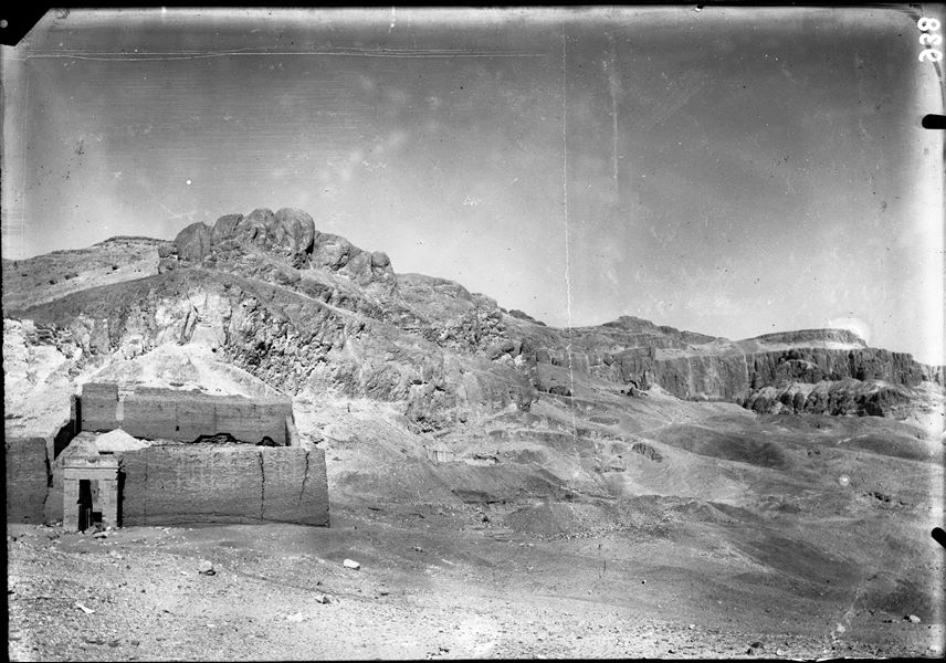 General view of the northern area of the necropolis. Clearly visible is the massive wall that borders the area of the temple. Above, the paths leading to the hill are visible, along with its small settlement. From here it is possible to descend to the Valley of the Kings or the Valley of the Queens, or climb to the top of the mountain. Schiaparelli excavations. 