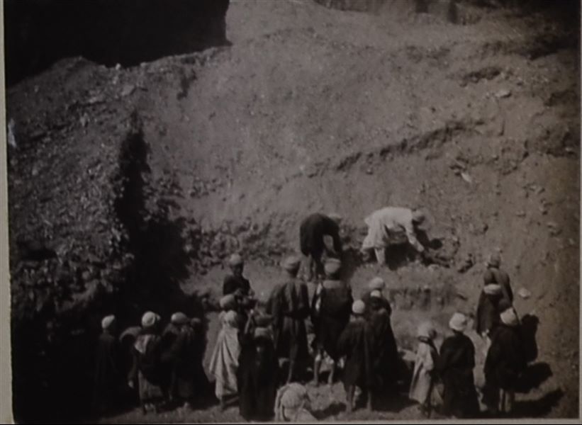 Photograph taken during excavations, at the moment of discovering the vases containing Demotic and Coptic papyri, still to be completely cleared of sand. Schiaparelli excavations. 