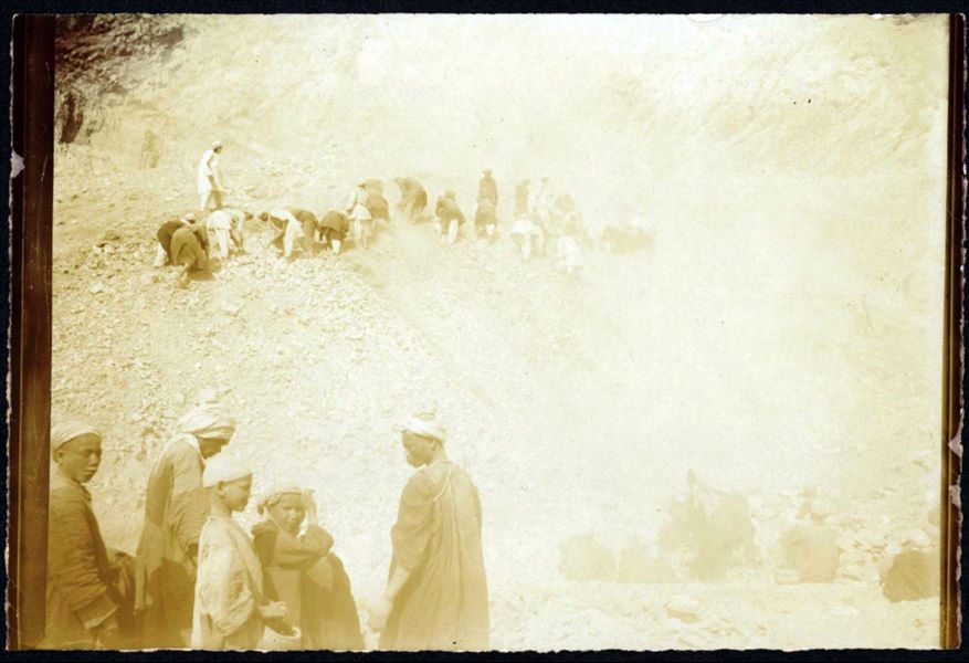 Excavating north of the temple of Hathor. Photograph blurred in the background, and overexposed. This print on paper has been toned with sepia. Schiaparelli excavations.