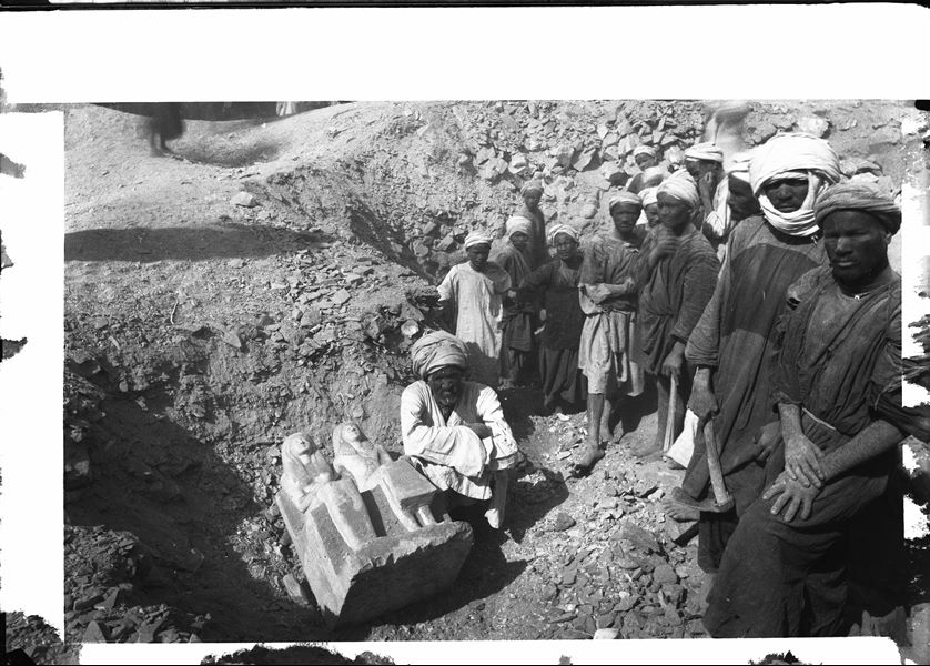 ​Excavations along the slope of the mountain, on the right side of the temple of the goddess Hathor. This photograph shows the moment of discovering the statue of Pendua and his wife Nefertari (S. 6127). Schiaparelli excavations. 