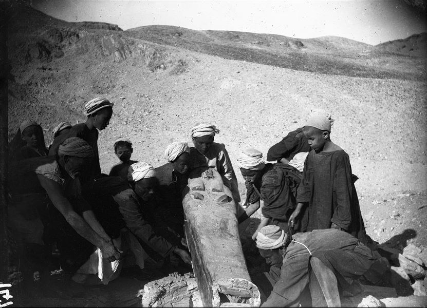 ​Excavations along the slope of the mountain on the right side of the temple of the goddess Hathor.  The removal of a sarcophagus from a tomb shaft, (S.07715). Schiaparelli excavations. 