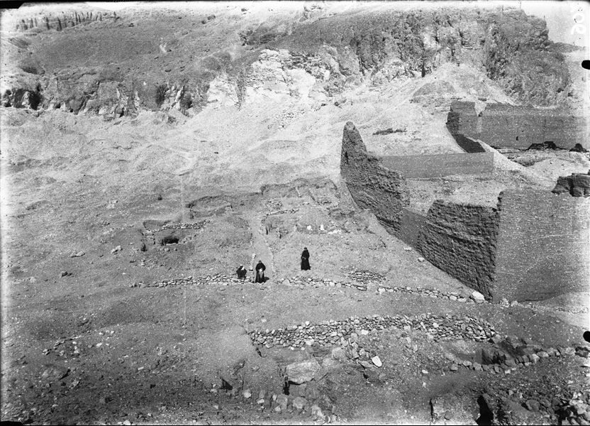Excavation area near the left wall of the temple of the goddess Hathor, before excavations began. Remains of ancient walls can be seen. Among them, ​​in addition to the gafir (guardian) are two Franciscan friars from the nearby Luxor mission. Schiaparelli relied on the clergymen for logistics. Schiaparelli excavations. 