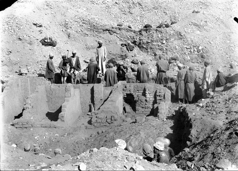 Excavations near the left boundary wall of the temple of the goddess Hathor. The excavation reveals raised mud-brick buildings, including shaft tombs and chapels. Schiaparelli excavations. 