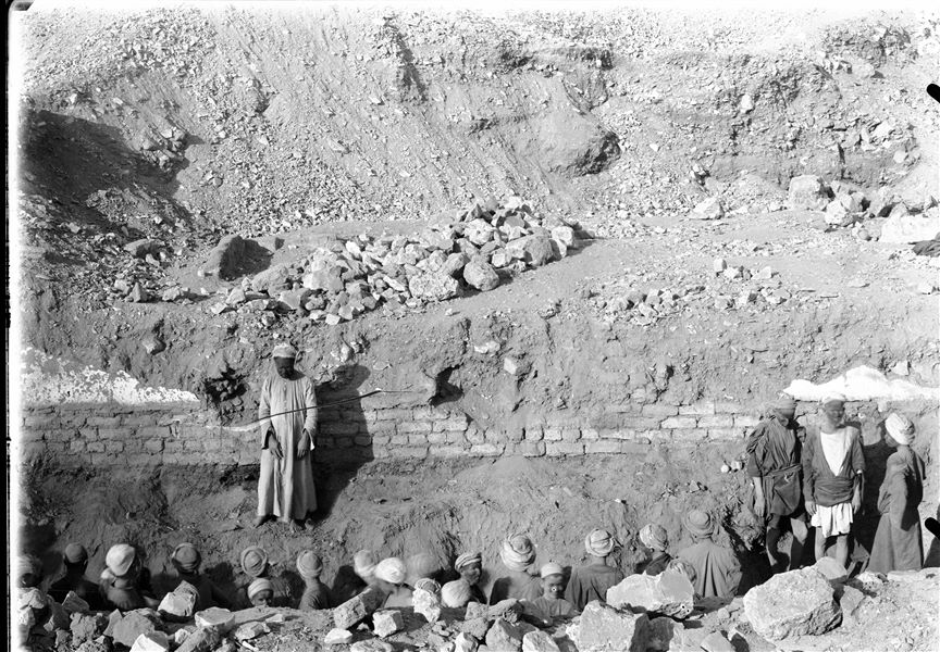 Excavation near the left boundary wall of the temple of the goddess Hathor. The excavation reveals a mud-brick wall, including pit tombs and chapels. The location is almost the same as in photographs C00884 and C00961, however the mud-brick wall is no longer present. Schiaparelli excavations.
