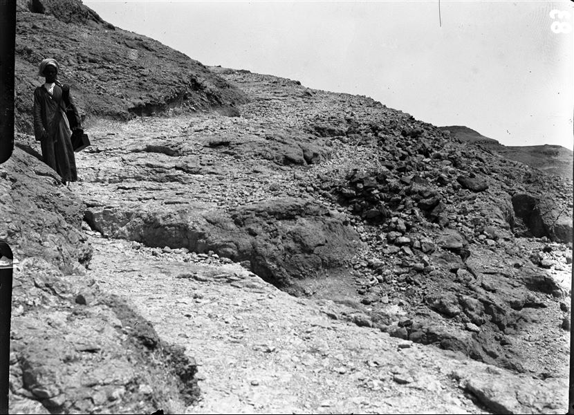 Mountain north of the Deir el Medina area. The picture shows a walkway leading to the top of the mountain. The man photographed is carrying a tube for drawings or maps and three cameras, one of which is an automatic film camera. Schiaparelli excavations.