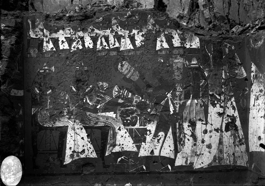 Parete sud della camera trasversale della tomba di Ipuy (TT217). Due figli portano offerte davanti alla coppia dei defunti, seduti. Il registro superiore invece mostra diverse persone sedute, rivolte verso una figura maschile in piedi.