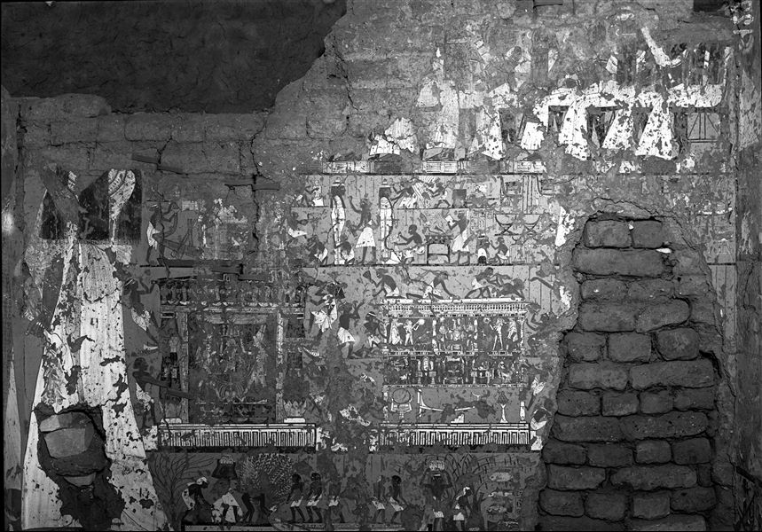North wall from the transverse chamber of the tomb of Ipuy (TT 217). On the left, the wife of Ipuy performs libations with her husband to Anubis and Ptah-Sokar (both  Ipuy and the god are on the west wall, north side, and not visible in this photograph). The wall has four registers, at the top, a man though not visible here is in front of his relatives. The two middle registers relate to funeral preparations, and the lowest register shows a fishing scene. 