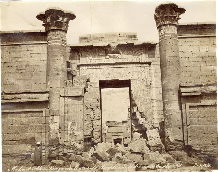 The photograph shows the entrance to the first courtyard of the so-called “Small Temple” from the 18th Dynasty. It is inside the enclosure of the Temple of Medinet Habu, on the west bank of the Nile in West Thebes, built by Pharaoh Ramesses III in the 20th Dynasty. Photograph taken before cleaning and restoration works The author's signature can be found at the bottom right. 
