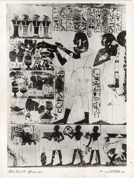 Wall painting scene from the Tomb of Djeserkaraseneb (TT38) (transverse chamber, east wing), who lived in the second half of the 18th Dynasty. In the scene, the deceased and his wife Wadjrenpet (behind her is a third person - their son, not visible here) make offerings to honour Amun-Re and Osiris. At present, the wall is partially ruined, in contrast to the state of preservation at the time of the photograph. The company Lehnert and Landrock (Egypt) was founded in the 1920s, therefore the photograph was taken later. Photograph probably taken by Rudolph Lehnert. 