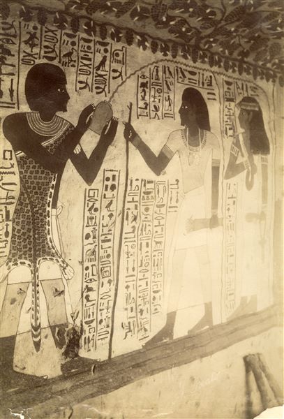 The photograph depicts a wall scene from the Tomb of Sennefer (TT96) burial chamber, north wall. He was  “Mayor of the Southern City” who lived during the reign of Amenhotep II in the 18th Dynasty. In the image, the deceased and his wife Meryt are purified by a Sem priest who is wearing a leopard’s skin. The author's signature is faintly legible at the bottom right-hand corner.