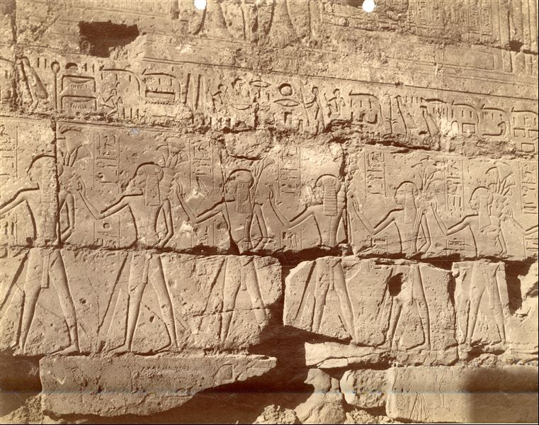 Nella fotografia è presentato un dettaglio del programma decorativo del cortile di Ramesse II nel Tempio di Amon a Luxor (angolo sud-occidentale), in cui si vedono sfilare alcuni dei suoi 17 figli.  