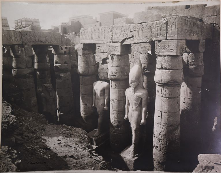 Fotografia di tre statue colossali del faraone Ramesse II, ancora situate nel grande cortile costruito dallo stesso faraone, nel tempio di Amon a Luxor. Erronea risulta pertanto l’indicazione del tempio posta sulla fotografia. In basso a sinistra si trova la firma dell’autore.