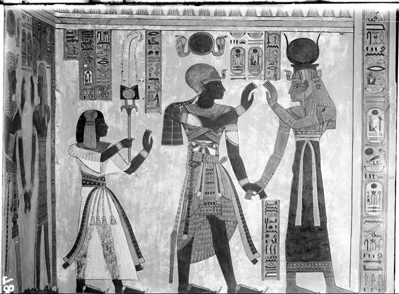 South wall (back) from the antechamber of the tomb of Amonherkhepeshef (QV55), east side (left) of the access to the burial chamber. The goddess Isis holds the hand of Pharaoh Ramesses III. On the left is Amonherkhepeshef. Schiaparelli excavations. 