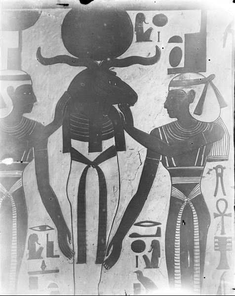 First eastern annex (alcove), west wall, south side, scene 15. A mummiform deity with a ram's head and sun disk - reminiscent of the characteristics of Osiris and Ra - is assisted by the goddesses  Nephthys (left) and Isis (right).