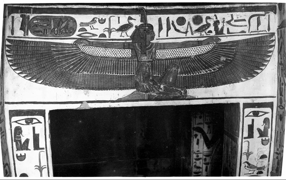 The winged goddess Maat is shown kneeling, depicted on the lintel of the entrance to the burial chamber (scene 28). She is facing east (right). 