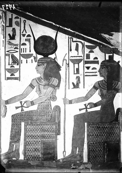 Descending corridor, west wall, scene 22. At the top of the descending corridor, there are three deities that receive offerings from Nefertari. In this photograph the goddesses Isis and Nephthys are depicted seated and facing the queen. 
