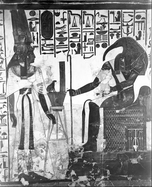 First eastern annex (alcove), north wall, scene 14. Nefertari is represented in front of the seated god Thoth. Between them is a container with scribal implements and a magical object in the form of a frog. Behind Nefertari, the initial part of Spell 94 of the Book of the Dead is visible. 