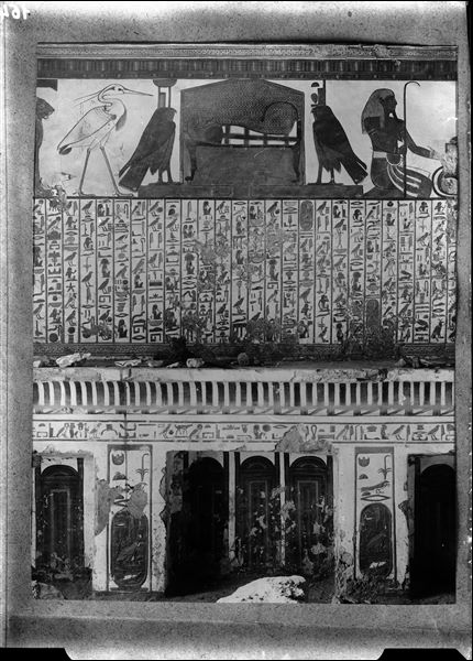 Detail of the central part of scene 3, showing a sarcophagus between two falcons representing the goddesses Nephthys and Isis. Several wall fragments can be seen on the shelf.