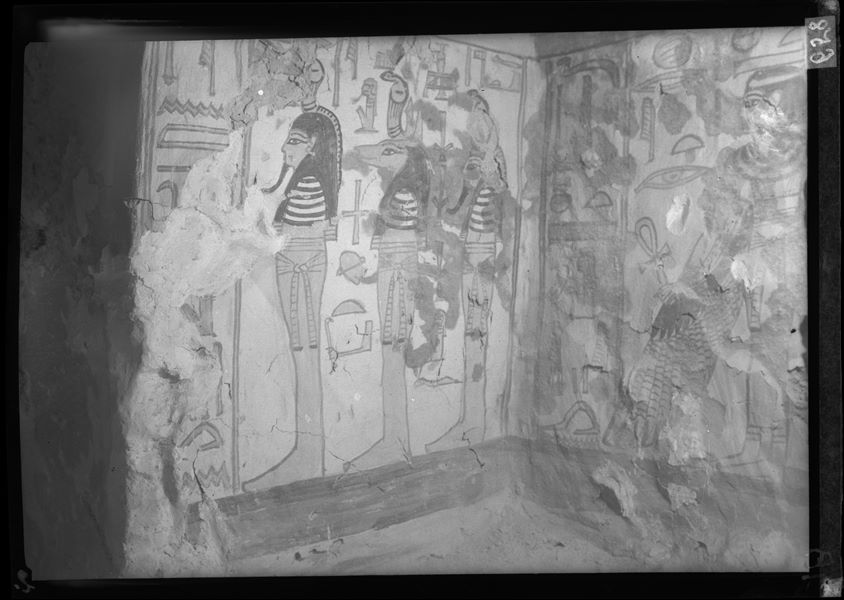 Burial chamber, small niche in the middle of the west wall, scene 32. The image shows the south wall of the niche depicting three mummiform figures: Imseti, Anubis and Qebehsenuf. The back wall (left), shows the winged goddess Nut.        (Pay attention that the photo was printed on the reverse side of the film)