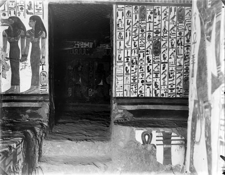 Camera funeraria, angolo sud-ovest. Si vedono due dei tre attendenti di guardia alla prima porta, la parete presenta poi (a destra) la continuazione del cap. 144 del Libro dei Morti. Al centro, l’accesso all’annesso occidentale.