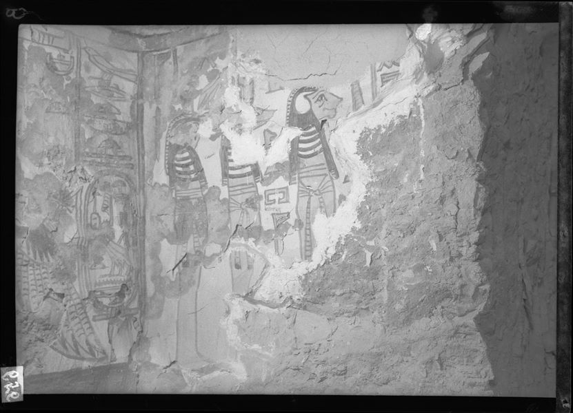 Camera funeraria, piccola nicchia al centro della parete ovest, scena 32. L’immagine presenta la parete nord della nicchia, con la rappresentazione di tre figure mummiformi, probabilmente Hapy, Anubi e Duamutef con testa di falcone. Oggigiorno una parte di intonaco di questa parete è crollata. La parete di fondo (a sinistra) presenta la dea Nut alata.