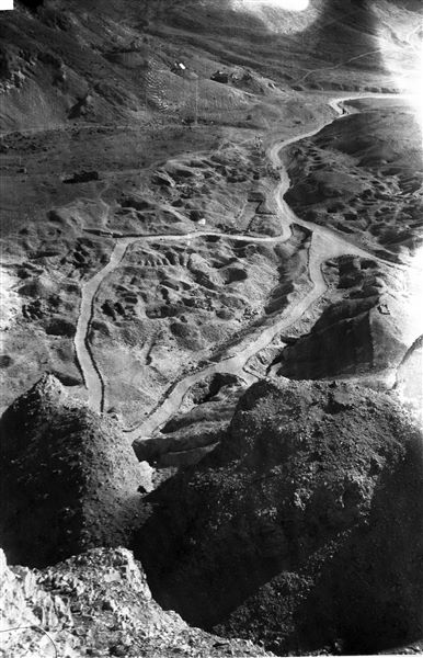 Veduta della Valle delle Regine, al centro è visibile l’ingresso, con struttura moderna in mattoni, della tomba della regina Nefertari (QV66). Fotografia scattata dal fondovalle. Sullo sfondo è visibile l'accampamento. Scavi Farina.