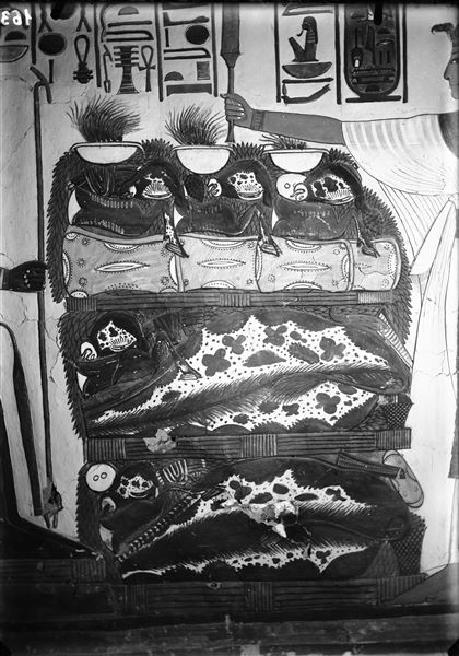 Primo annesso orientale (alcova), parete est, scena 18. Dettaglio della un tavolo colmo di offerte rappresentate tra Nefertari e il dio Atum assiso. L’iscrizione soprastante, da una parte rappresenta l’invocazione di Nefertari con le offerte per il dio, dall’altro la risposta benevola del dio.