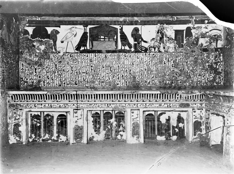 Veduta dell’anticamera, parete ovest, scena 3. Nel registro superiore, è presente Atum tra due leoni, l’uccello Benu, la mummia su un letto tra due falchi, rappresentazioni di Neftys e Iside. Queste sono raffigurazioni connesse con il registro centrale, che presenta il cap. 17 del Libro dei Morti. Sotto, infine, a sinistra è presente una decorazione composta da pilastri Djed e nodi Tit, mentre al centro vi è un ripiano con modanatura a gola egizia, con rappresentazioni di santuari. Da notare il soffitto stellato.